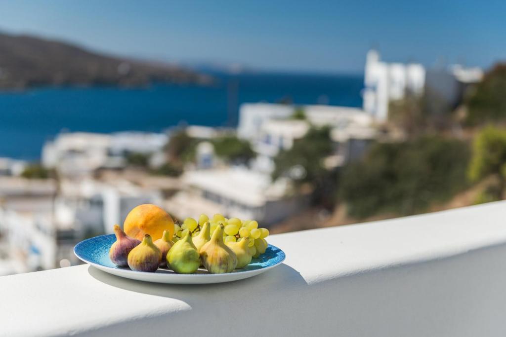 a plate of fruit on a balcony with a view at Kaerati Apartments in Katapola