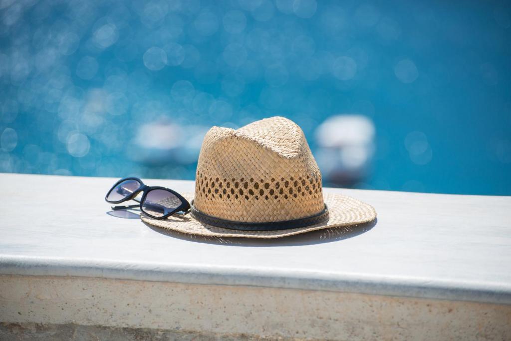 a straw hat and sunglasses sitting on a table at Kaerati Apartments in Katapola