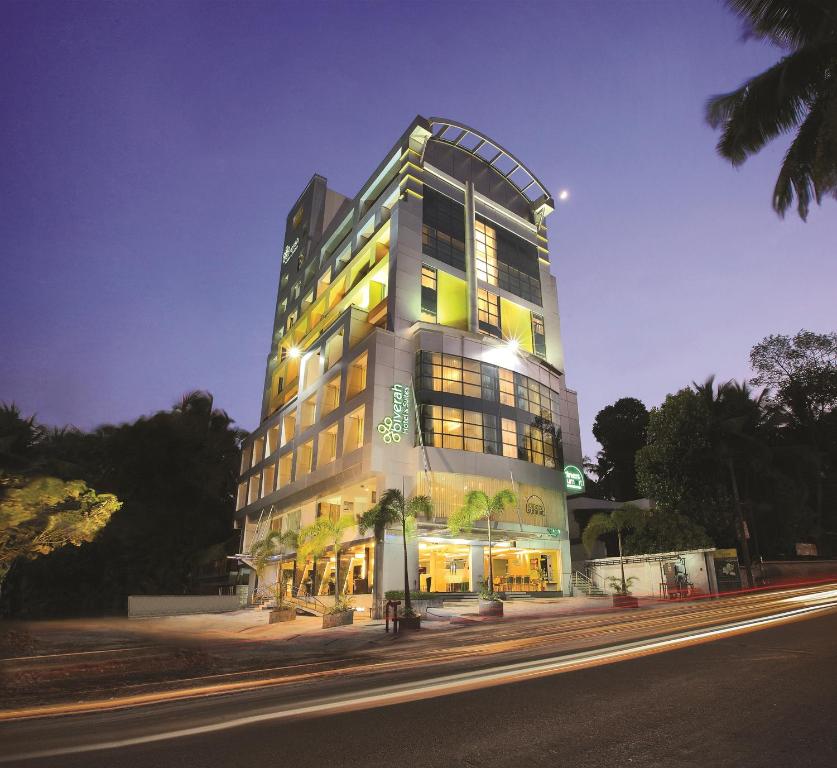 wysoki budynek jest oświetlony w nocy w obiekcie Biverah Hotel & Suites w mieście Thiruvananthapuram