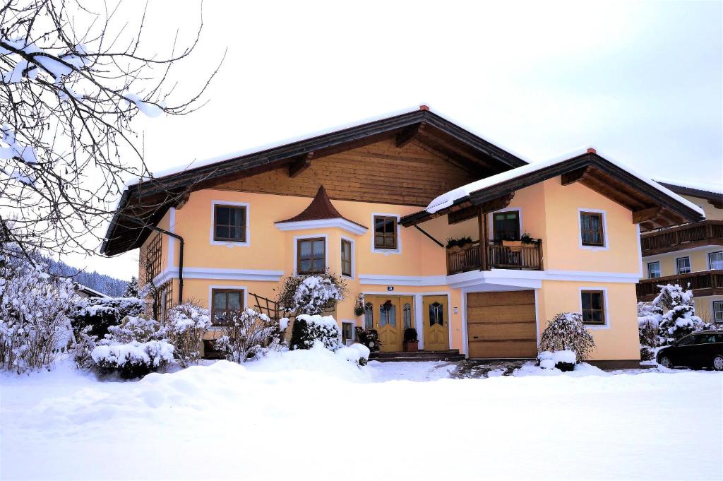 una casa con nieve en el suelo en Haus Huber Apartments en Altenmarkt im Pongau