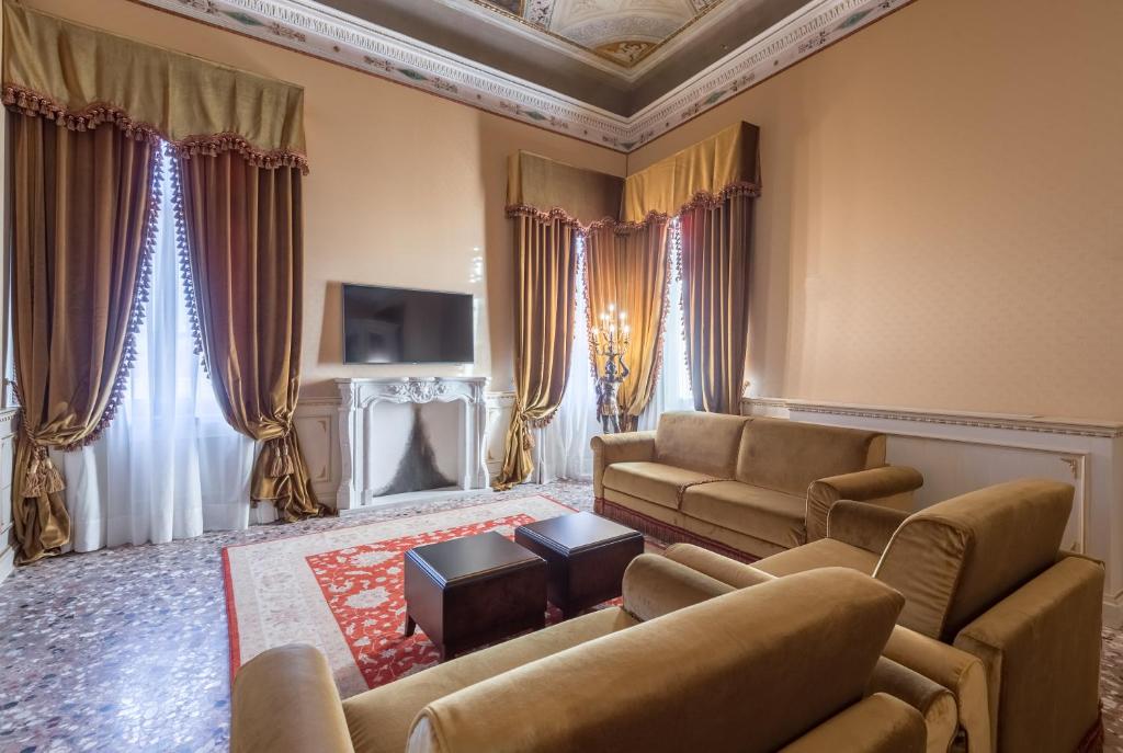 a living room with two couches and a tv at Hotel Nani Mocenigo Palace in Venice