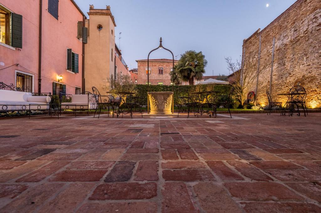 a patio with tables and chairs in a courtyard at Hotel Nani Mocenigo Palace in Venice