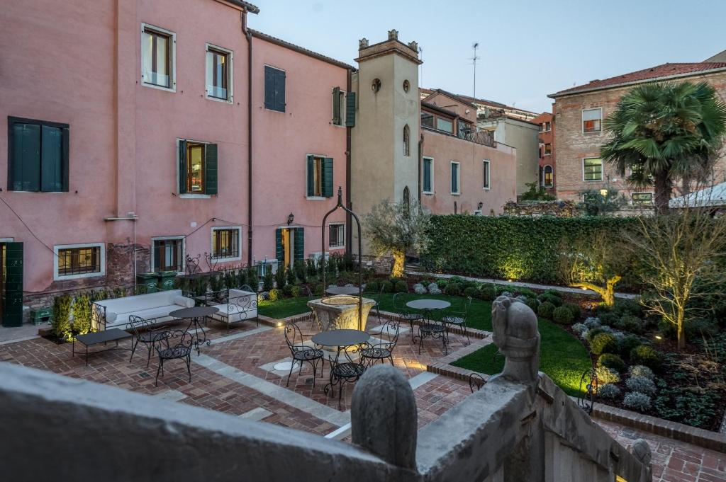 a courtyard with tables and chairs and buildings at Hotel Nani Mocenigo Palace in Venice
