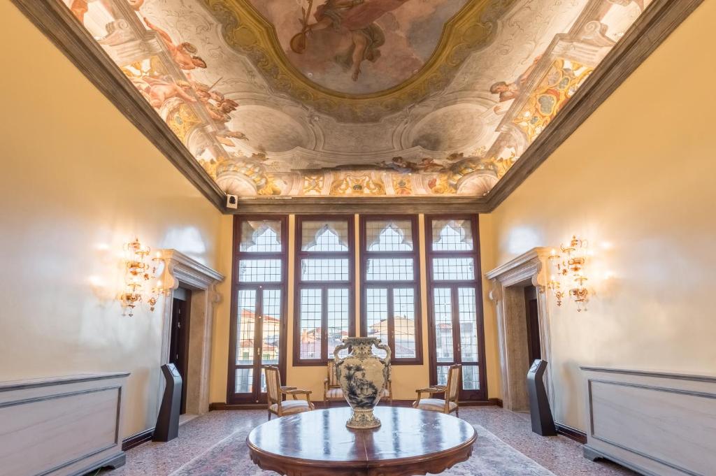 a room with a ceiling with a vase on a table at Hotel Nani Mocenigo Palace in Venice