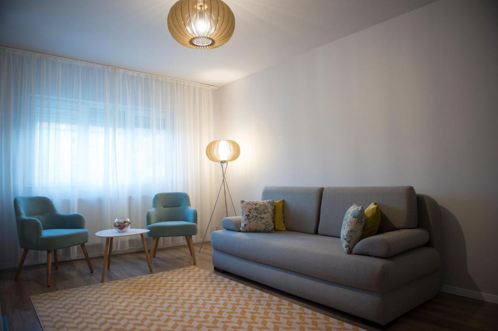 a living room with a couch and two chairs at SMP Apartment 2 in Timişoara