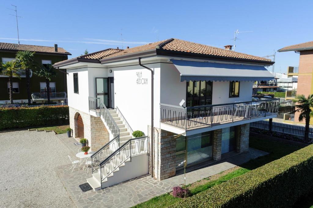 a white house with a balcony and stairs at Villa Azdora in Peschiera del Garda