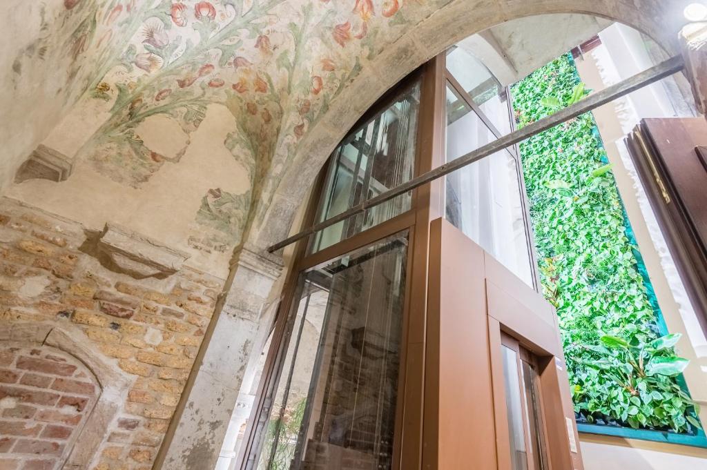 a room with a painting on the wall and windows at Hotel Nani Mocenigo Palace in Venice