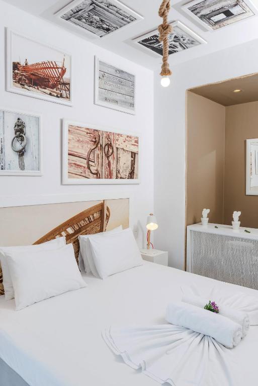 a white bedroom with a large white bed at Kaerati Apartments in Katapola