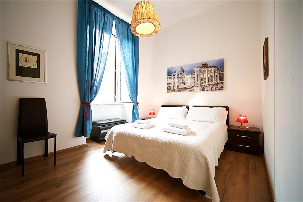 a bedroom with a bed and a window with blue curtains at Vetrina Holidays Apartment Navona in Rome