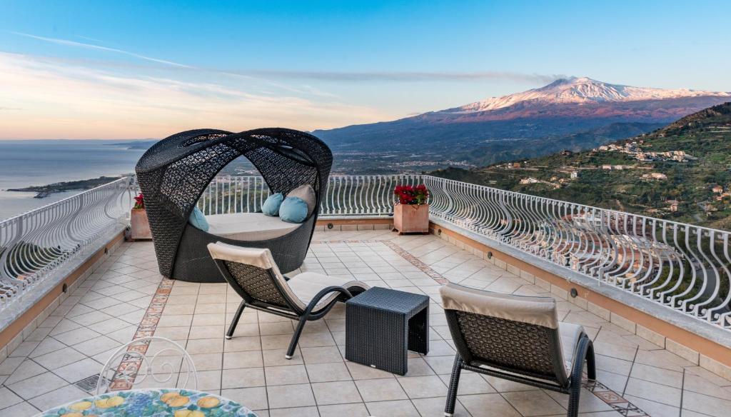 a balcony with chairs and a view of a mountain at Villa Le Terrazze Charming Rooms in Taormina