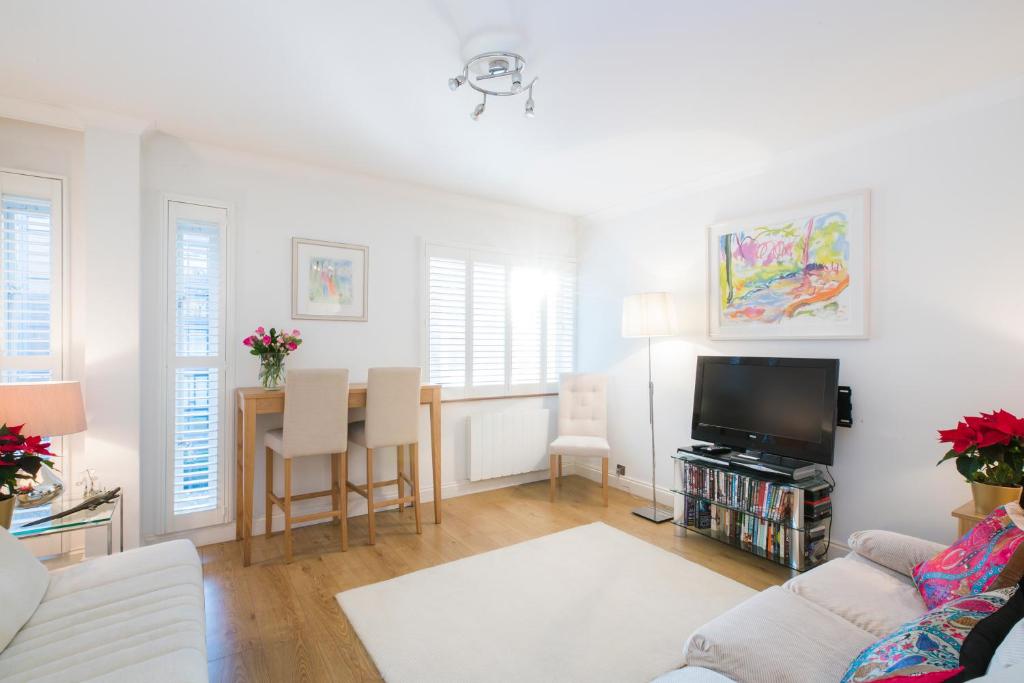 uma sala de estar com um sofá e uma televisão em Sublime 1 bed flat with Thames view em Londres