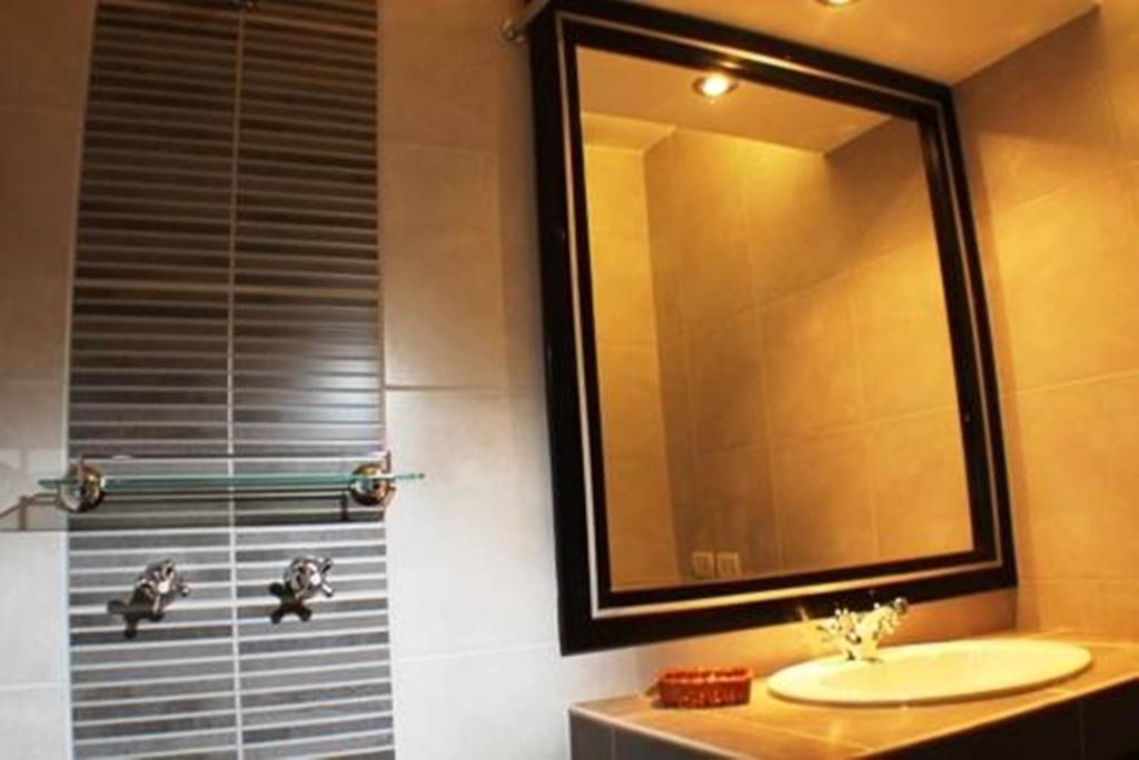 een badkamer met een wastafel en een douche met een spiegel bij Tampu Hotel in Cuzco