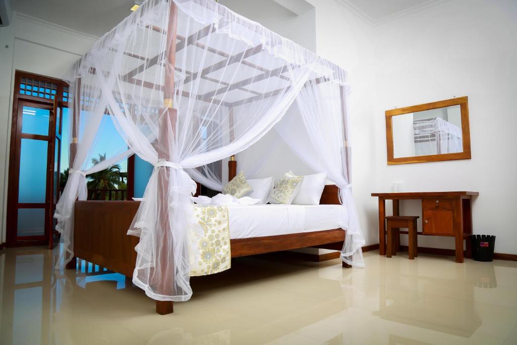 una camera da letto con un letto a baldacchino di BV Residence a Tangalle