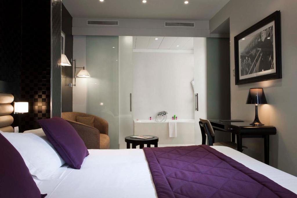 Habitación de hotel con cama y escritorio en Hotel Icône, en París