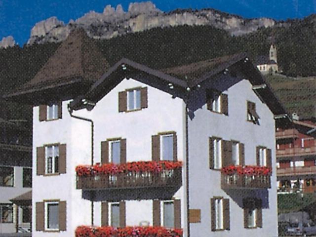 a large white building with flower boxes in front of it at B&B Rosalpina in Vigo di Fassa