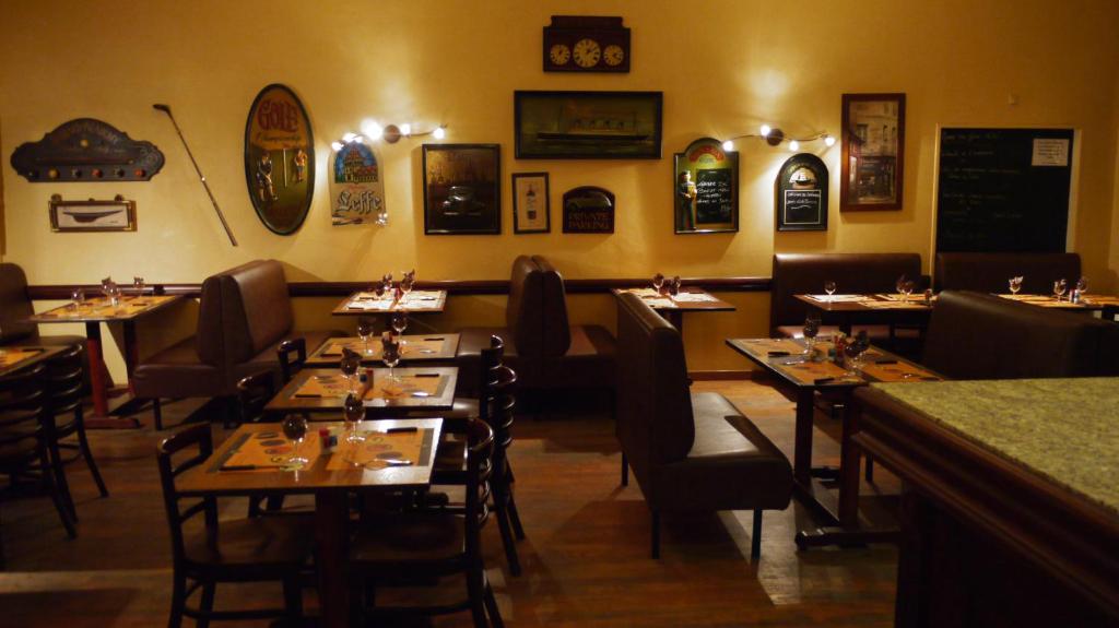 una sala da pranzo con tavoli e sedie in un ristorante di Hôtel Belleville a Lamalou-les-Bains