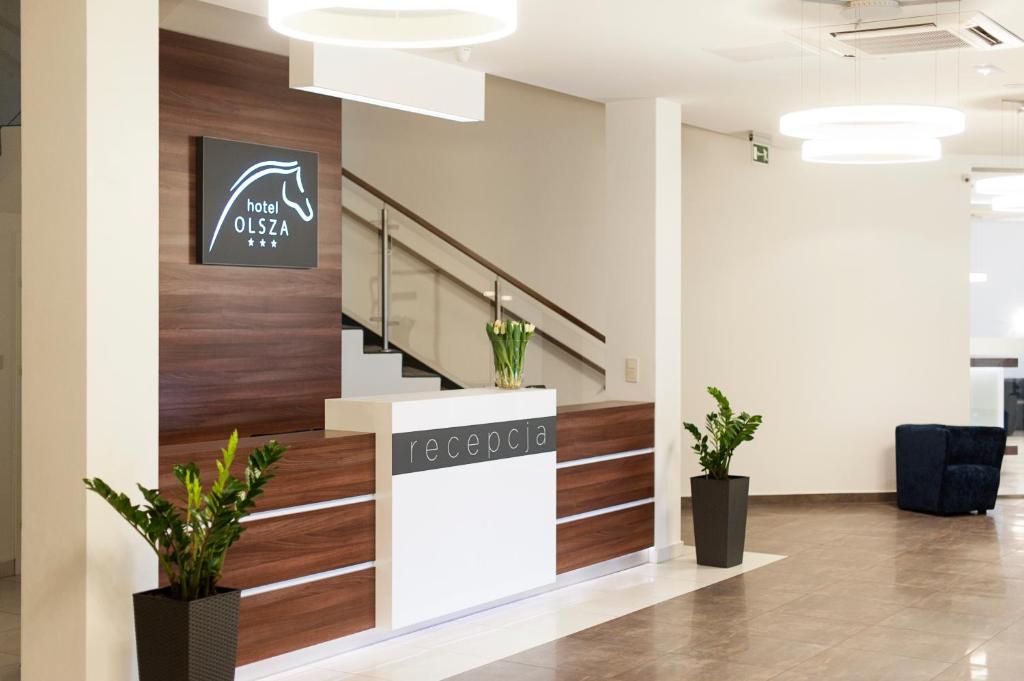 an office lobby with a staircase and plants at Hotel Olsza in Olszówka