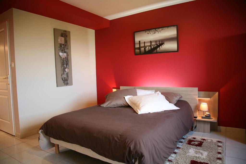 1 dormitorio con una pared roja y 1 cama en Domaine Du Coteau Des Lys, en Fleurie
