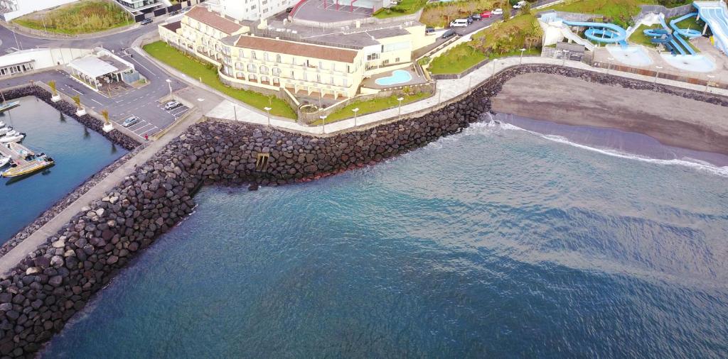 an aerial view of the ocean and a pier at Vinha da Areia Beach Hotel in Vila Franca do Campo