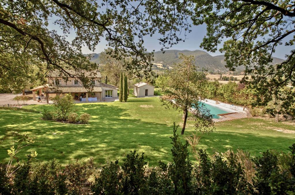 フォッソンブローネにあるCasale Bellaguardiaの家とスイミングプールのある庭の景色を望めます。