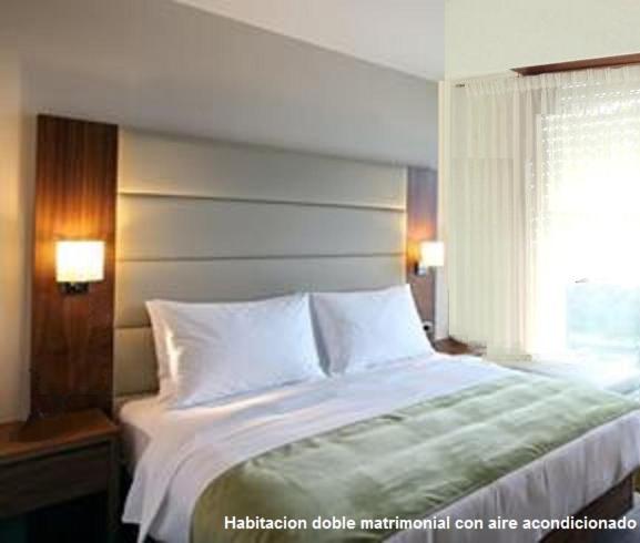 Un dormitorio con una cama grande y una ventana en Dino´s Hotel en Villa Gesell
