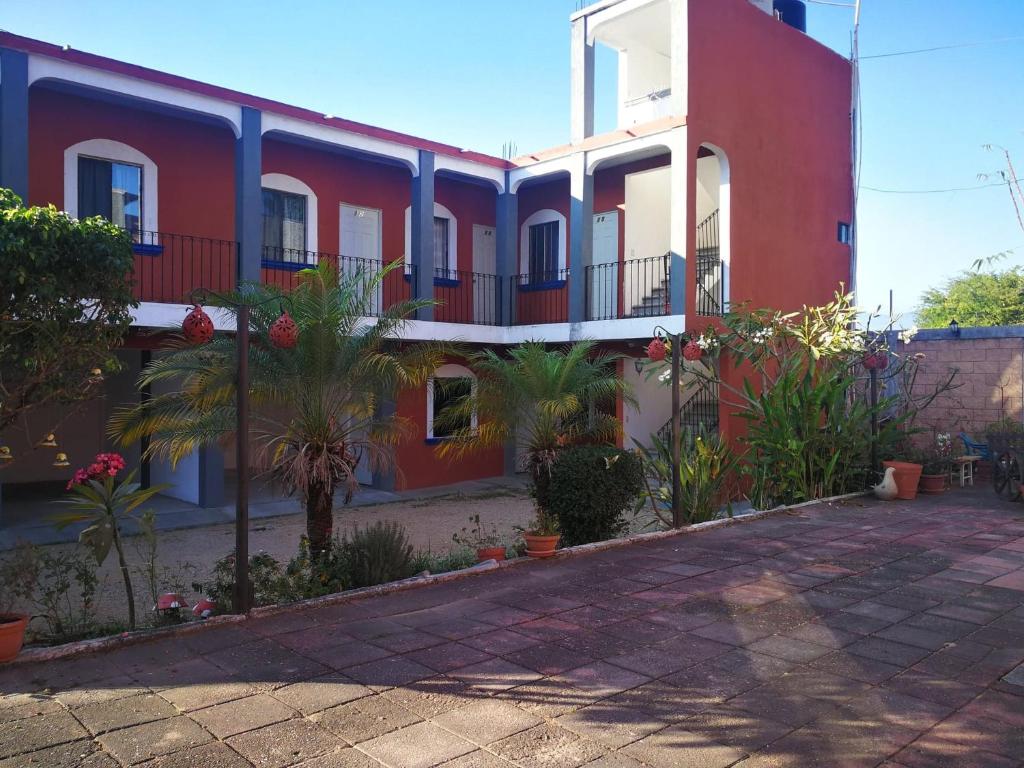 un bâtiment rouge et blanc avec des plantes devant lui dans l'établissement Hotel Casa Zoque Colonial, à Tuxtla Gutiérrez
