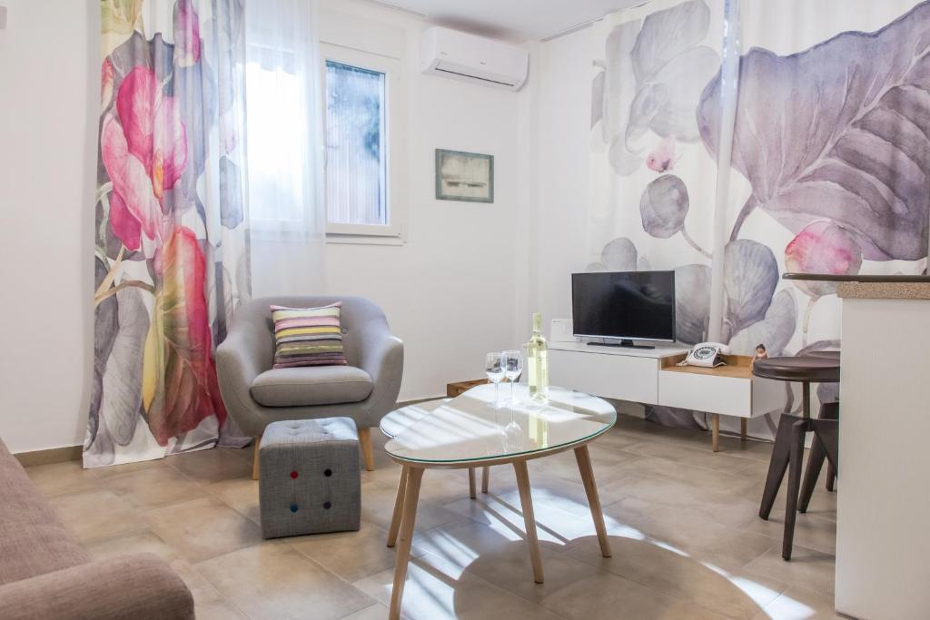 a living room with a couch and a table and a tv at Acropolis Quiet Apartment in Athens