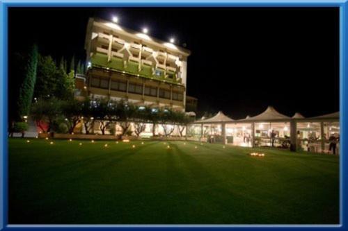 a large building with a lawn in front of it at night at Hotel Isola di Lauria in Lauria Inferiore