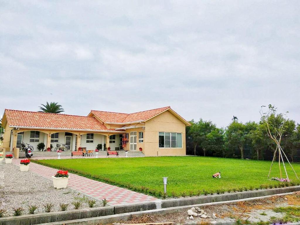 a house with a green lawn in front of it at Yuzhou Garden B&B in Taitung City