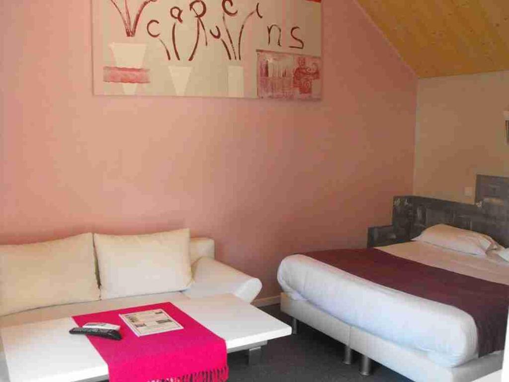 Postel nebo postele na pokoji v ubytování Logis Hôtel Restaurant Les Capucins