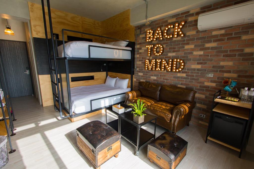 a room with a bunk bed and a couch at We Love Inn in Hualien City