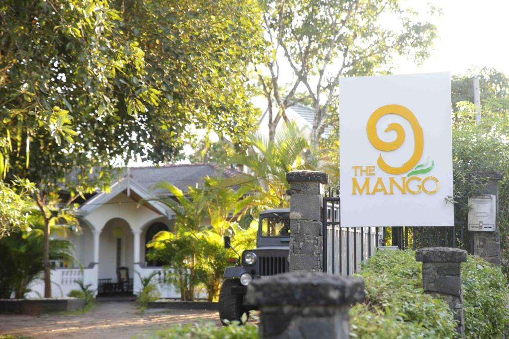ein Schild vor einem Haus mit einem Haus in der Unterkunft The Mango in Kandy