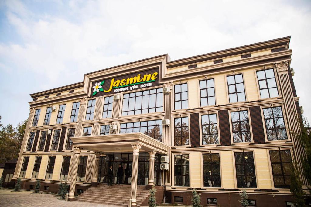 a large building with a sign on top of it at Jasmine in Taraz