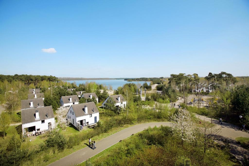 una vista aerea di un villaggio con case e un lago di Sunparks Kempense Meren a Mol