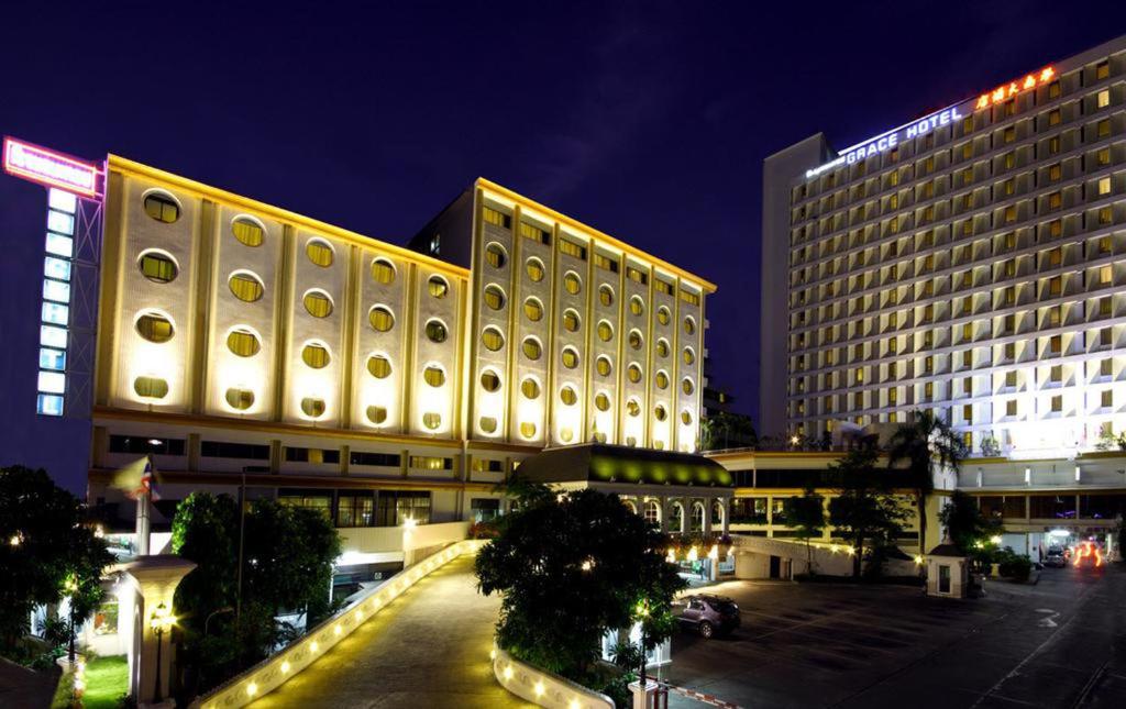 a large building with a parking lot in front of it at Grace Hotel in Bangkok