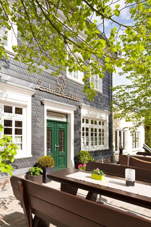 a building with a green door in front of it at Zu den Drei Linden - Hotel & Restaurant in Wermelskirchen