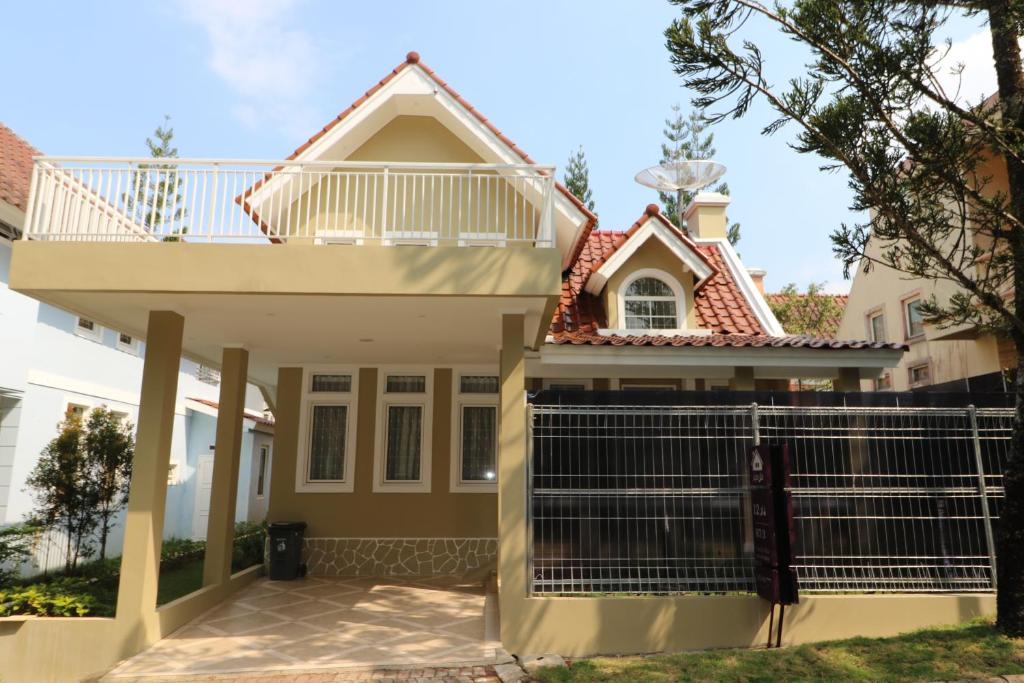 uma casa com um portão em frente em Diyar Villas Puncak R7-3 em Puncak