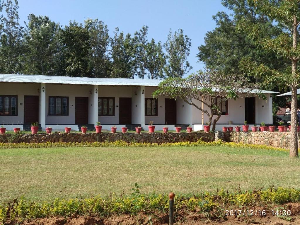a building with a lawn in front of it at Singaras Coffee Country in Masinagudi