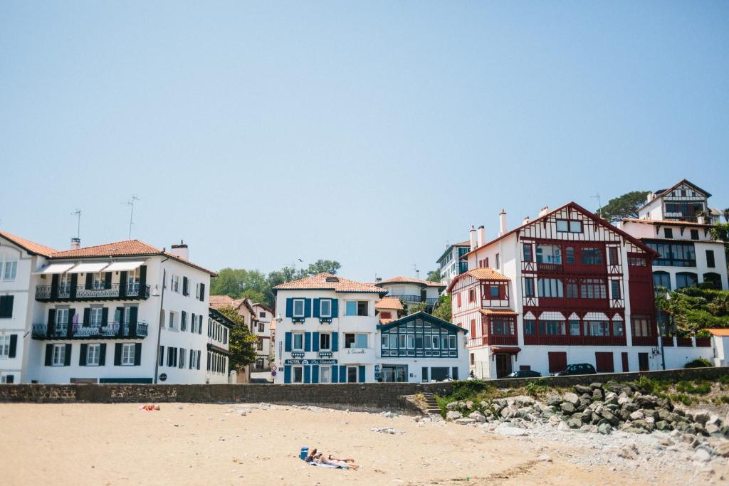 un grupo de edificios en una playa con una playa en Hôtel La Caravelle, en Ciboure