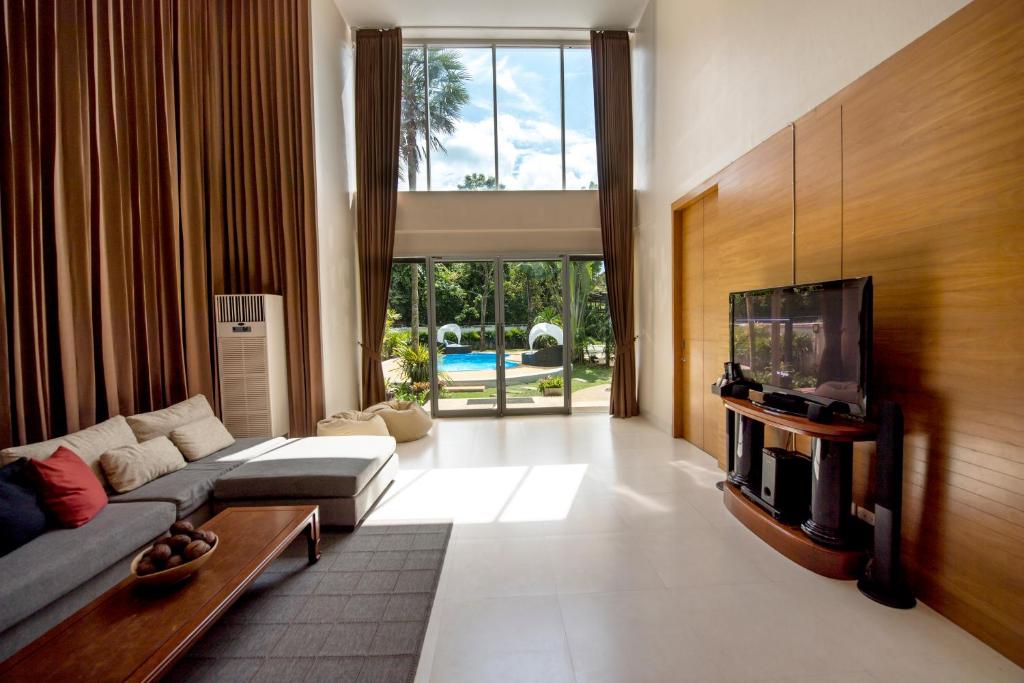 a living room with a couch and a flat screen tv at Villa Kanwara in Ao Nang Beach