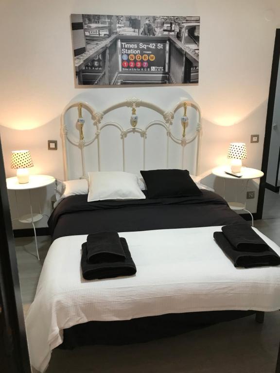 1 dormitorio con 2 camas y toallas negras. en Alojamiento El Cantal, en Santoña