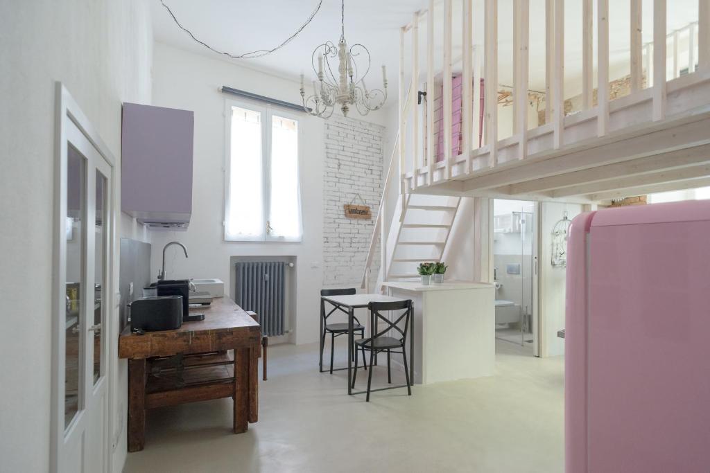 cocina y sala de estar con mesa y escalera en New loft in the heart of Bologna, en Bolonia
