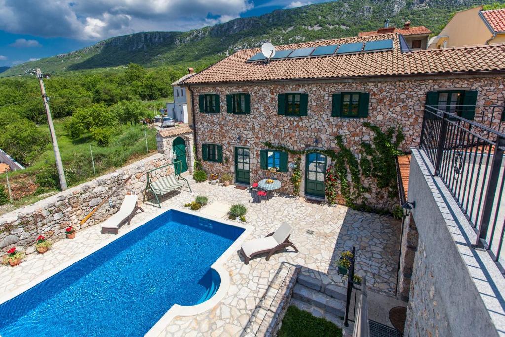 an external view of a house with a swimming pool at Villa Oliva Bribir in Bribir