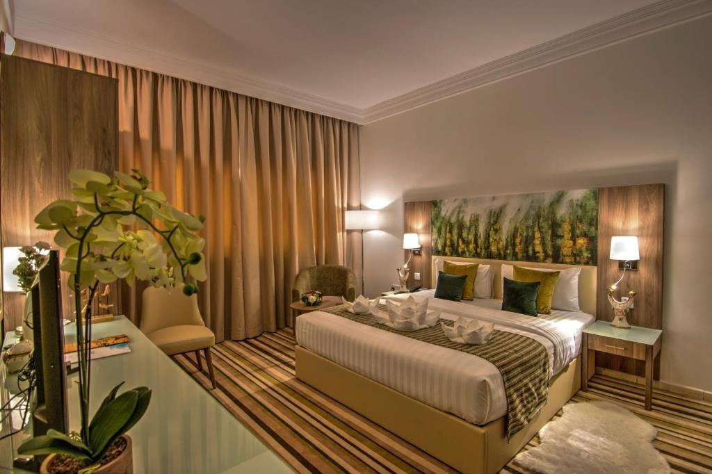 um quarto com uma cama grande e uma pintura na parede em Royal View Hotel em Ras al-Khaimah