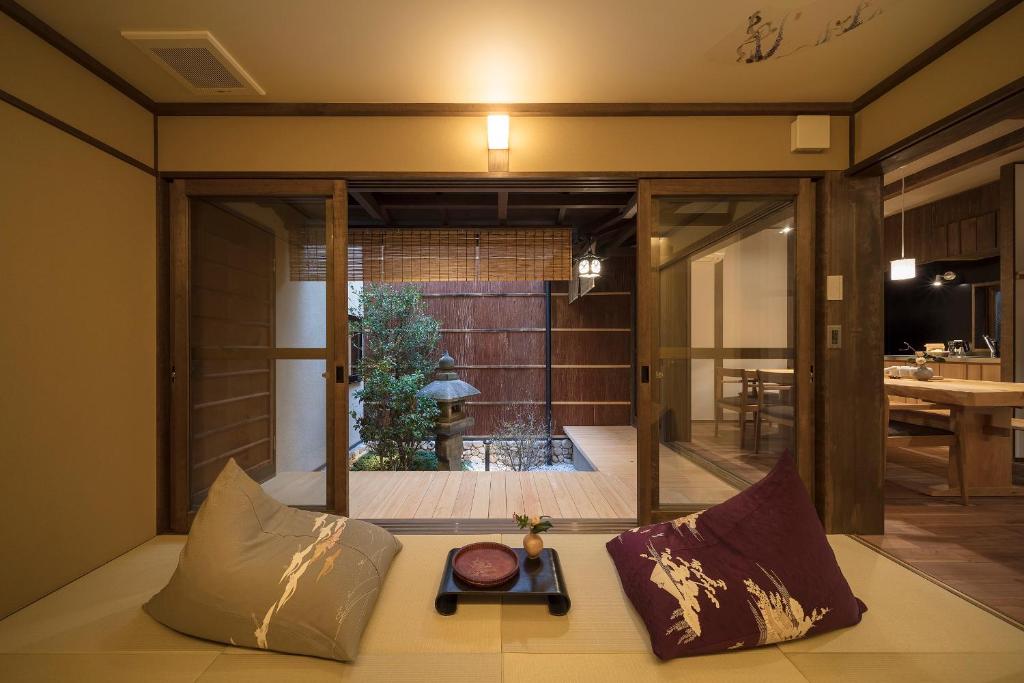a room with a couch with pillows on it at Fujinoma Machiya House in Kyoto