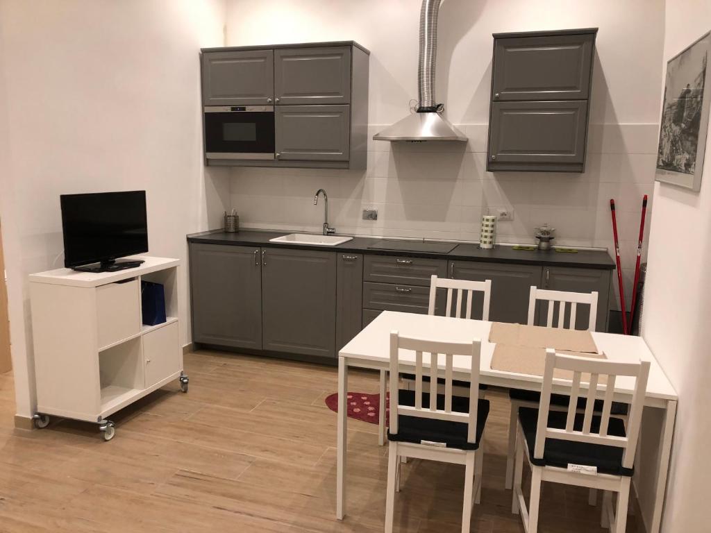 a kitchen with a table and chairs and a sink at San Lorenzo University flat in Rome