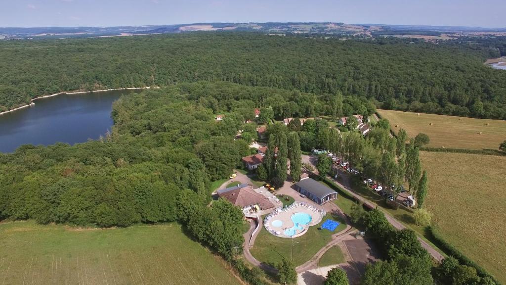 an aerial view of a house and a lake at VVF Bourgogne Auxois Morvan in Semur-en-Auxois