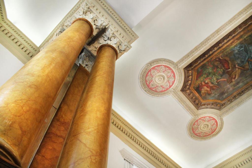 a pillar in a room with a ceiling and a painting at Hotel Villa Delle Rose in Rome