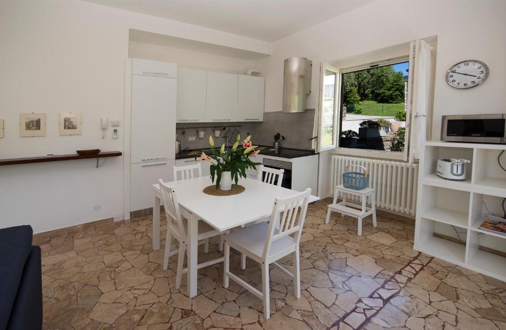 een keuken met een witte tafel en stoelen en een tafel bij Vitali Apartment JR in Bellagio