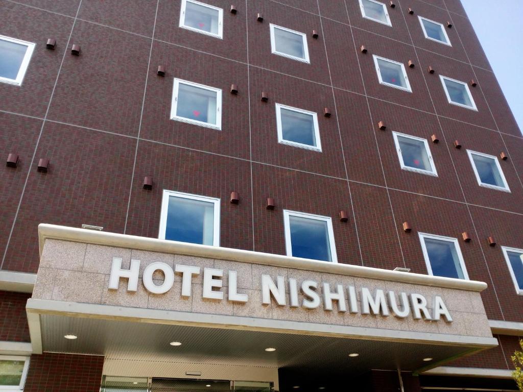 una señal de hotel frente a un edificio en Hotel Nishimura, en Fuji